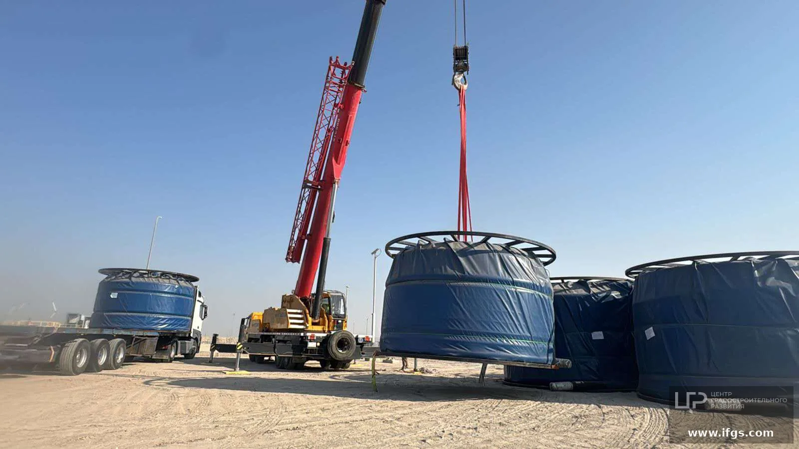 Crane lift of blue-tarped RTP reel at site